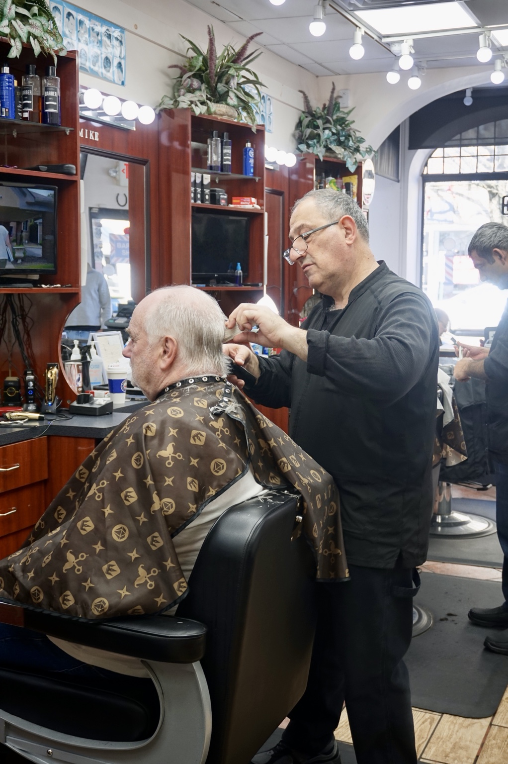 A barber adding finishing touches to a haircut