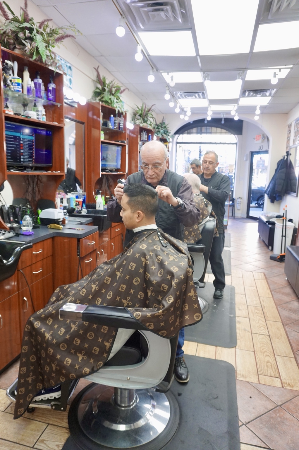 The barber shop interior with a haircut in progress