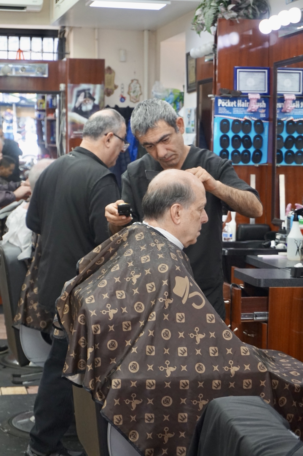 A barber and customer at the styling station